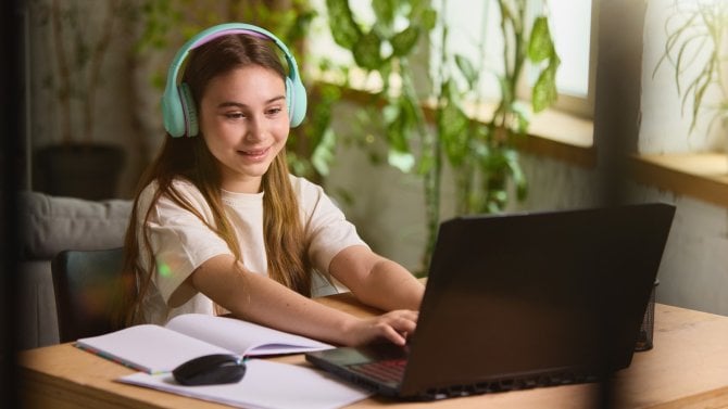 Dospívající dívka sedí u počítače