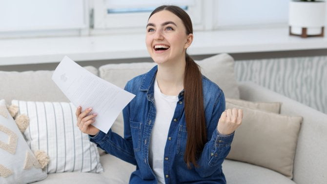 Mladá Studenka se raduje dokumentu držícího v ruce o ukončení školy