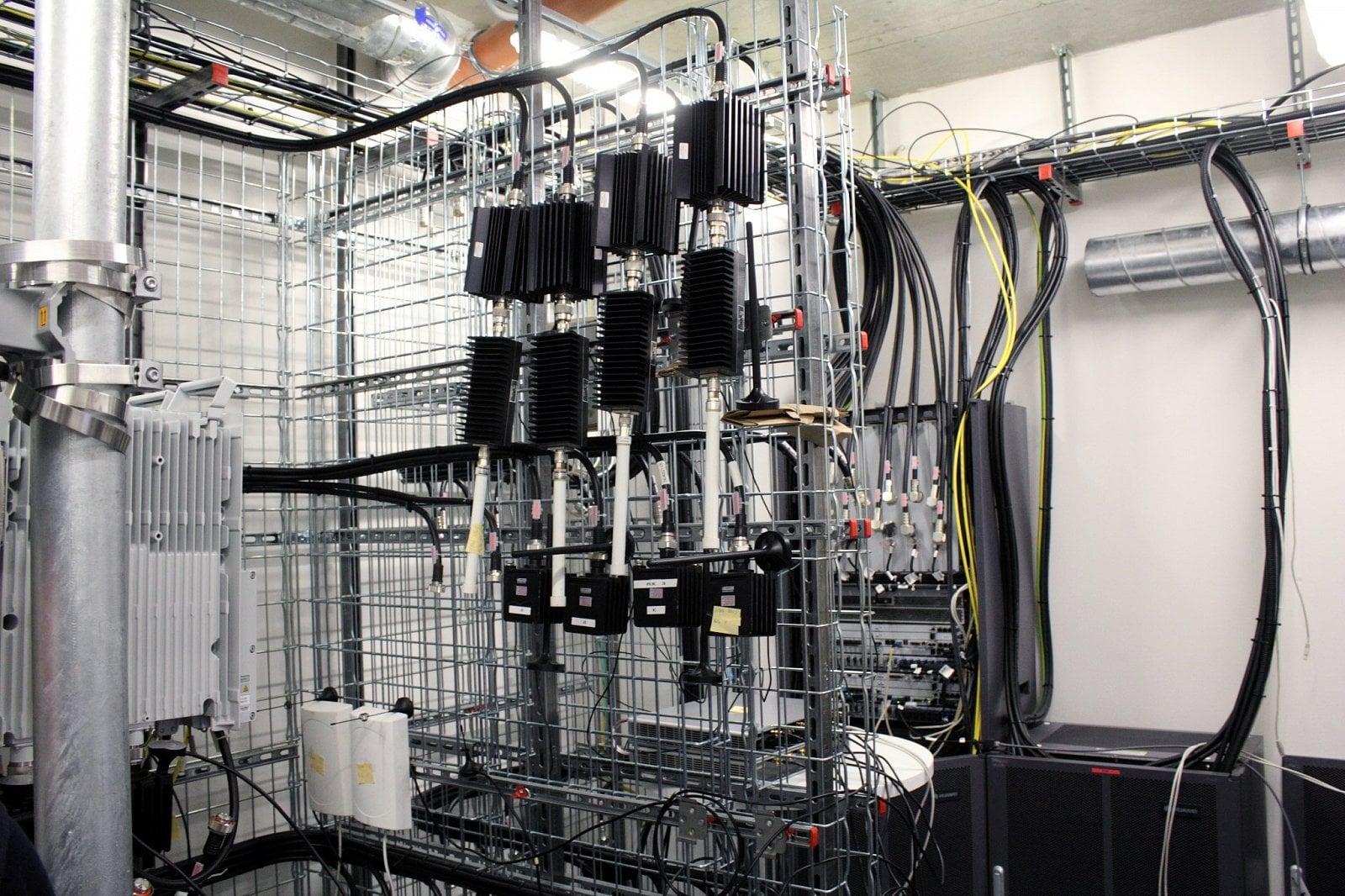 Teď ale Vodafone ve své laboratoři zkouší agregaci čtyř pásem. Testovací místnost je malá a přeplněná vysílacími jednotkami, přijímacími anténami a dalším příslušenstvím.