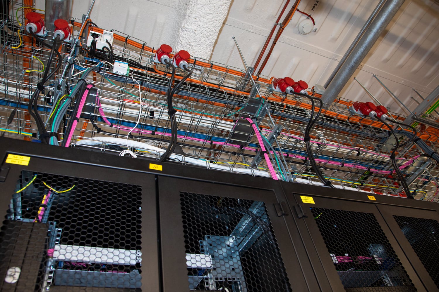 Napájení racků odshora, kaskáda žlabů pro kabelové rozvody.