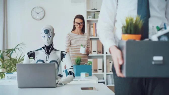 dva lidé v kanceláři, muž nese krabici s věcmi, robot připravil člověka o práci