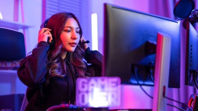 Asijské krásné esport žena hráč hrát online videohry na počítači. Atraktivní dívka herní hráč cítit šťastný a vychutnat vysílání živého streamování, zatímco hrát kyberturnaj v neon místnosti doma.