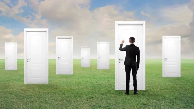 Podnikatel na louce klepe na jedny z vícero dveří