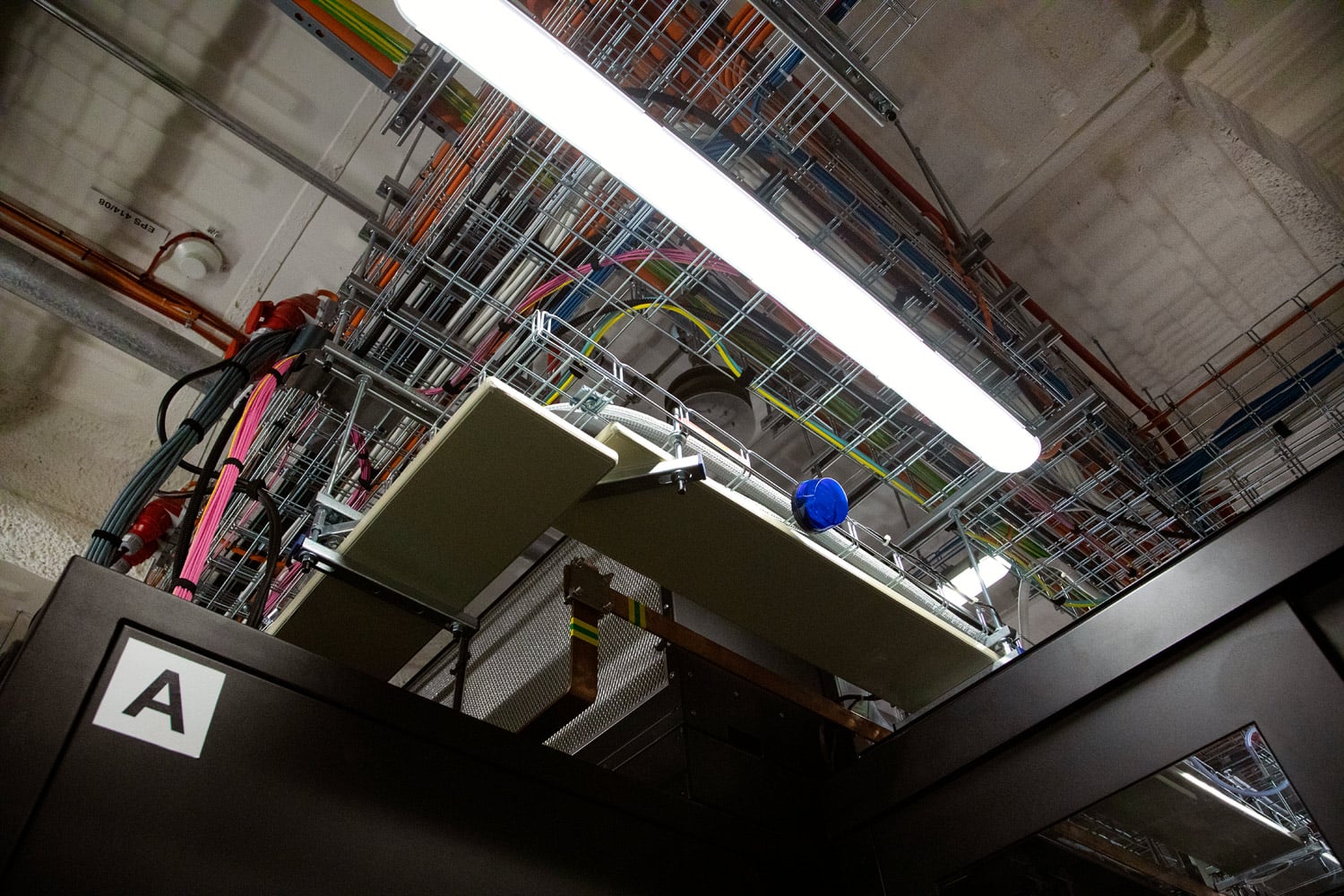 Modrá signalizace dlouho otevřených dveří do studené uličky.