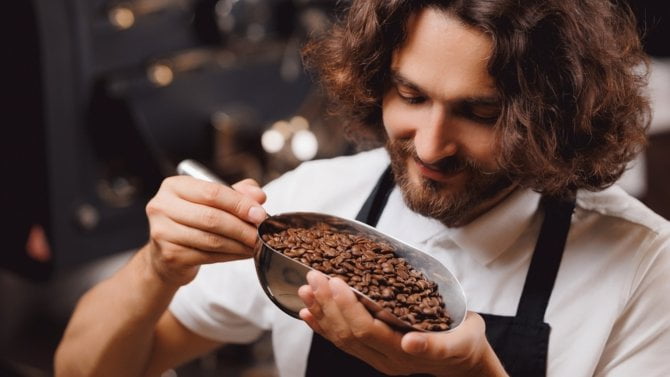 Mladý muž se zrnkami kávy