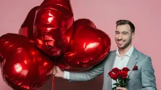 Muž s balónky a květinami na Valentýna