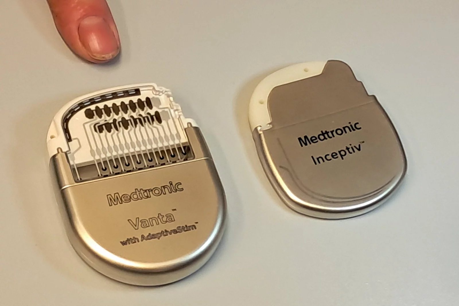 Původní typ baterie je vlevo, baterie nového stimulátoru pak leží vedle ní. K miniaturizaci dochází už řadu let a je to pro pacienty dobře. Pro všití je třeba jen malé operační rány, navíc baterie v podkoží pacientovi nijak nepřekáží, pokud třeba chce spát na boku či zádech.