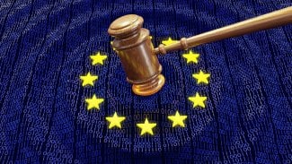 Soudní kladivo dopadající na vlajku EU