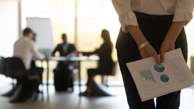 Zadní pohled zblízka podnikatel drží doklady o finančních statistikách za zády čekat na výkon řeč cítí nervózní. Sebevědomý generální ředitel připravený k prezentaci na pozadí klienti sedí u stolu v zasedací místnosti