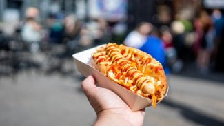 Ruka svírající hot dog.