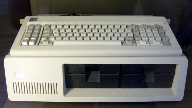 IBM PC 5150 se dvěma disketovými mechanikami a klávesnicí položenou na skříni.
