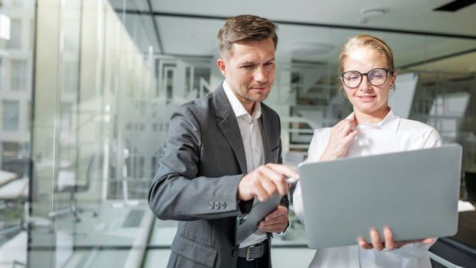 Dva úředníci kontrolují s úsměvem dokumenty