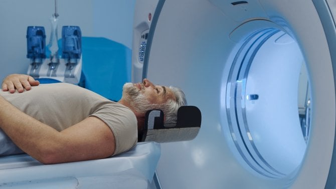 Starší muž se podrobuje vyšetření na počítačovém tomografu (CT)