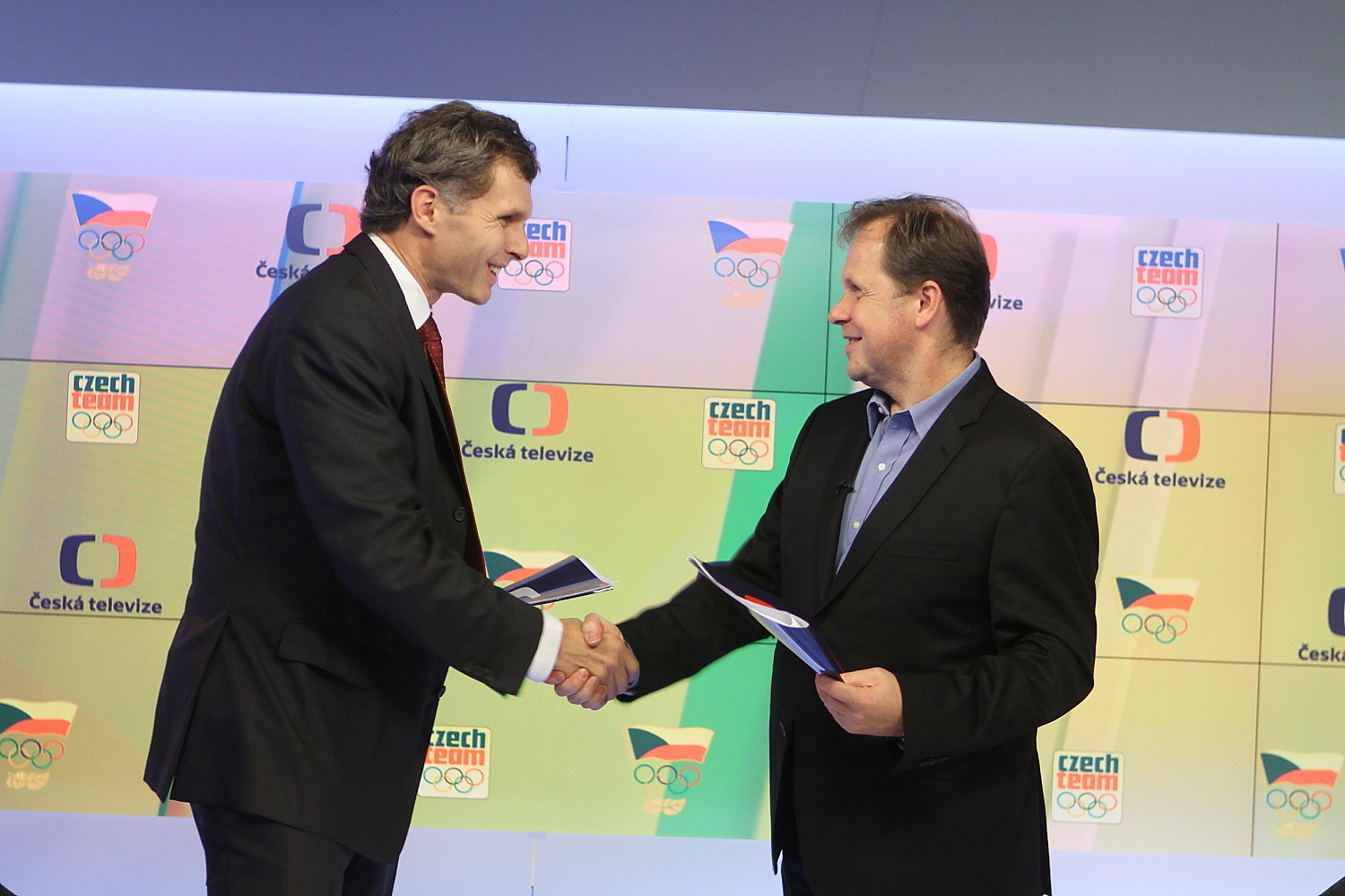 Generální ředitel České televize Petr Dvořák a předseda Českého olympijského výboru Jiří Kejval zakončují akt vzájemným podáním rukou.