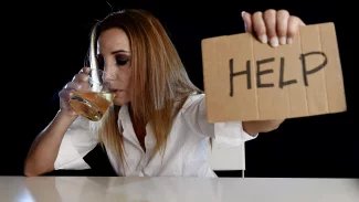 Žena se skleničkou v ruce potřebuje pomoc se závislostí na alkoholu