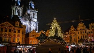 Na obrázku je centrum Prahy, Staroměstské náměstí, které je vánočně vyzdobené. Stánky a vánoční strom. V pozadí stojí Týnský chrám