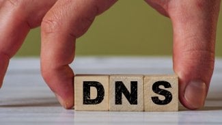 Ruka držící kostky s písmeny DNS