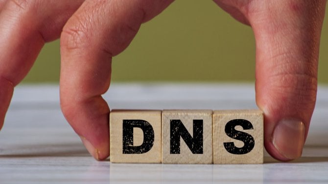 Ruka držící kostky s písmeny DNS