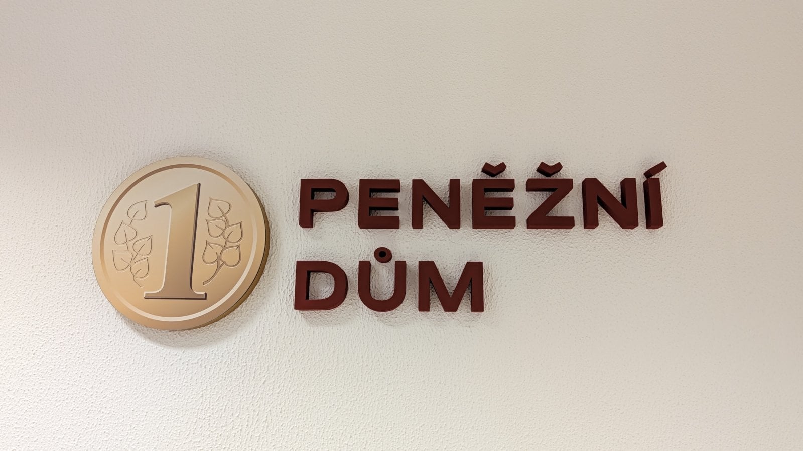 Logo uvnitř pobočky a centrály Peněžního domu, spořitelního družstva. Havlíčkova 1221, Uherské Hradiště (23. 09. 2026)
