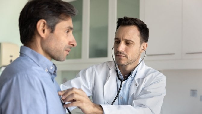 Lékař vyšetřuje muže stenoskopem