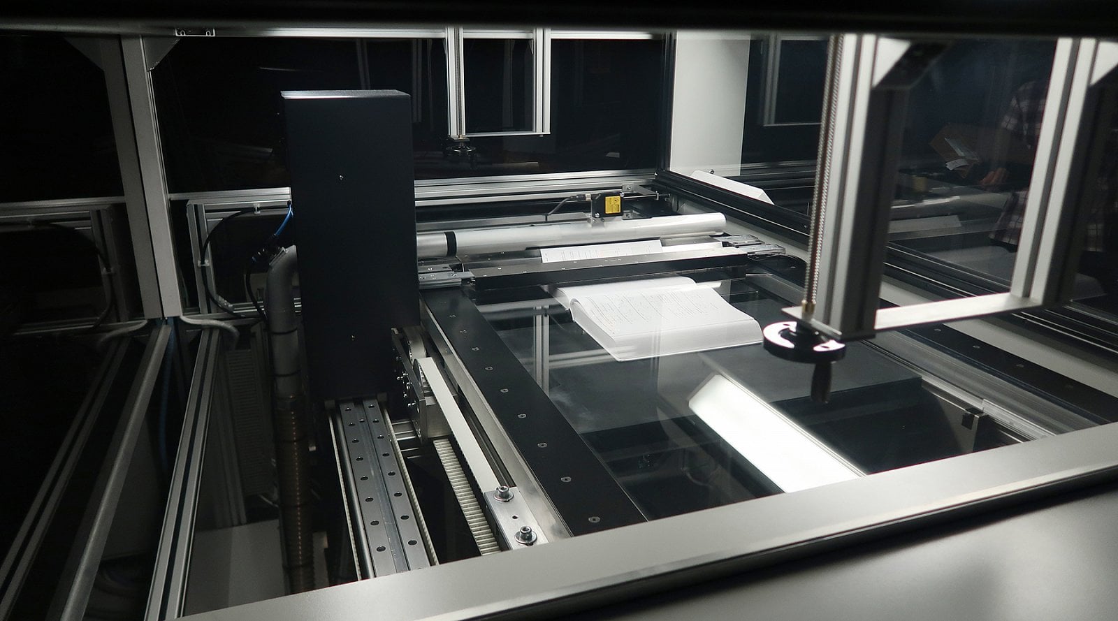 Strana je po naskenování podtlakem zdvižena a šetrně obrácena. Skener 4DigitalBooks DL 3003.