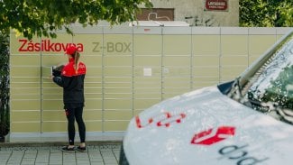 Řidička přepravní společnosti DPD ukládá zásilku do výdejního boxu Zásilkovny.