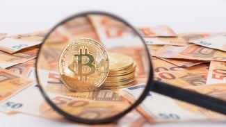 Bitcoin pod lupou s eury v pozadí
