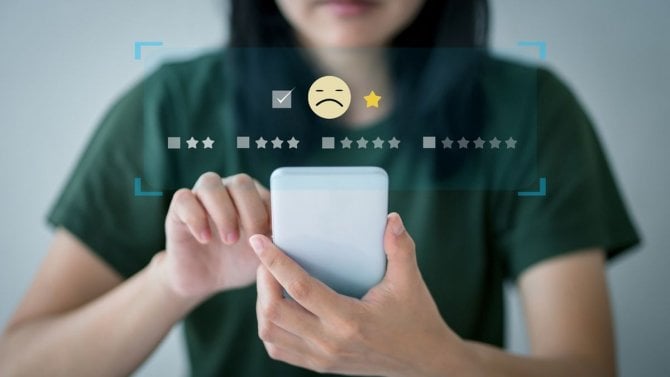 Nespokojený a zklamaný zákazník, který dává nízké hodnocení v průzkumu, smutný obličej na obrazovce smartphonu, špatná uživatelská zkušenost.