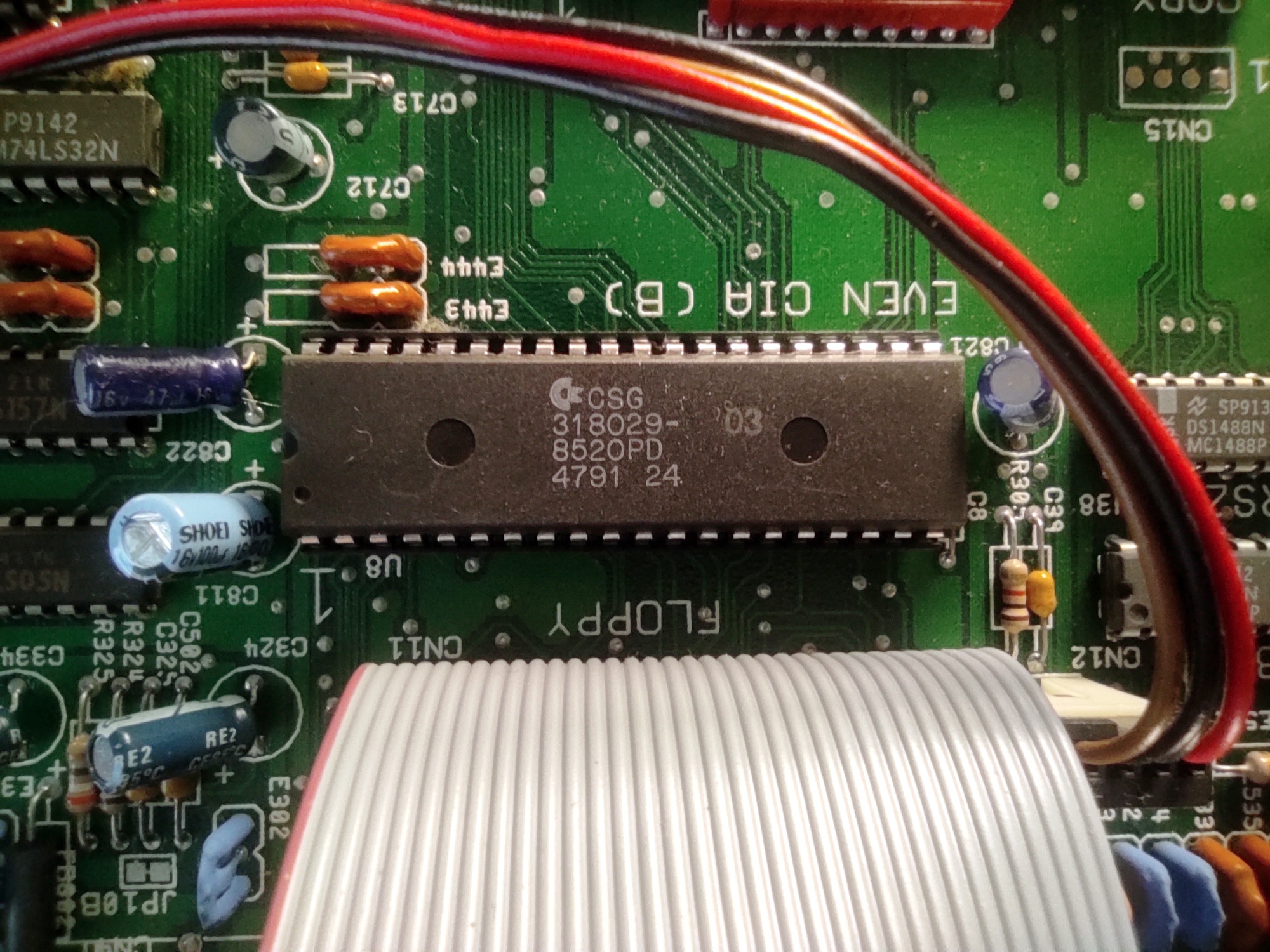 Detail na jeden ze dvojice CIA čipů (zde Even), floppy kabel a drobná elektrotechnická bižuterie.
