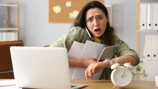 Žena v kanceláři ve stresu honí termíny a má moc práce