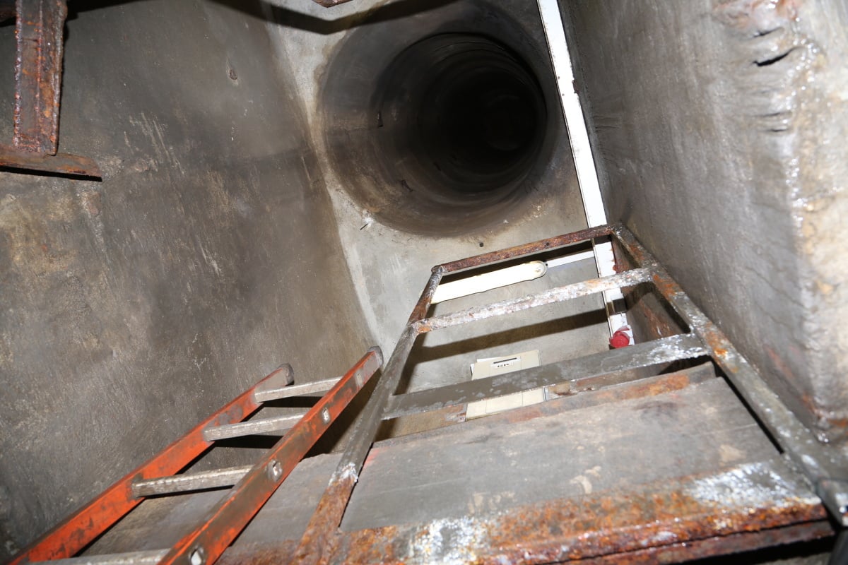 Na zlomek vteřiny do něj nahlédneme jen díky blesku fotoaparátu. Jsme pod rušnou ulicí a shora je pravidelně slyšet "buch-buch", jak auta přejíždějí přes poklop. "Víko má asi 96 kg," říká Máca.