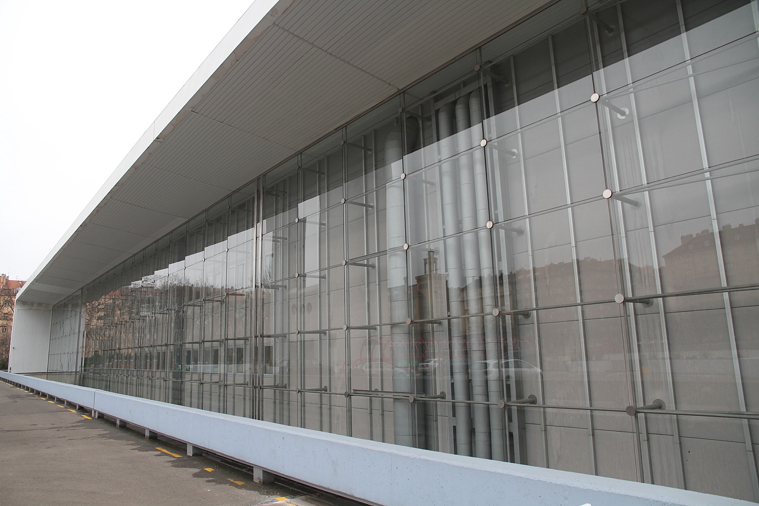 Sklo, beton a příkop s ostnatým drátem.