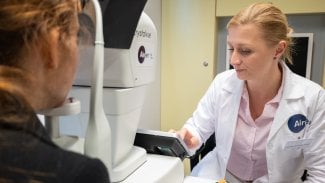 Zdravotnice vyšetřuje oči s pomocí fundus kamery Aireen vybavené AI