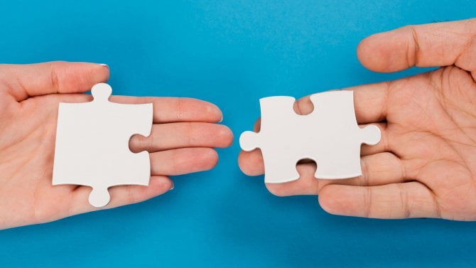 Mužské a ženské ruce spojující puzzle kousky na barevném pozadí reprezentující týmovou spolupráci spolupráce synergie kreativní problém řešení integrační strategie připojení konceptu.