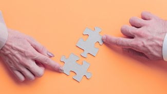 Mužské a ženské ruce spojující puzzle kousky na barevném pozadí reprezentující týmovou spolupráci spolupráce synergie kreativní problém řešení integrační strategie připojení konceptu.