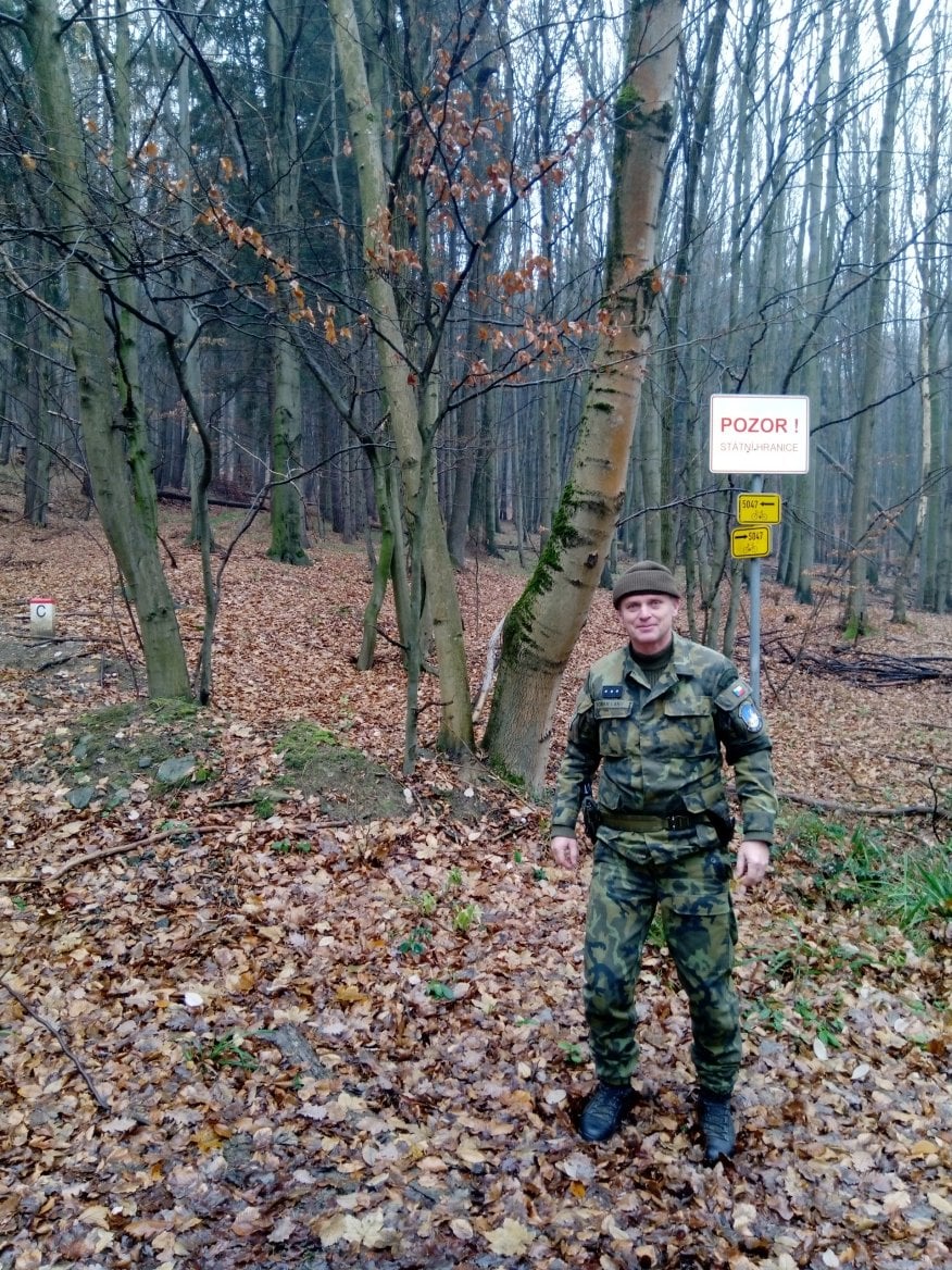Muž v maskáčovém oblečení v lese
