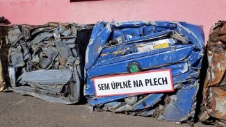 Modré sešrotované auto značky Škoda do plechové kostky.