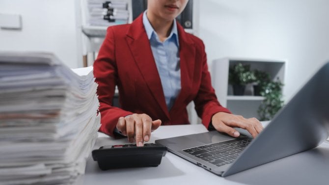 Žena evidující množství dokumentů do počítače