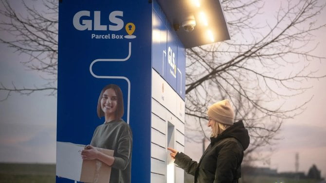 Žena si podvečer vyzvedává balíček z GLS boxu