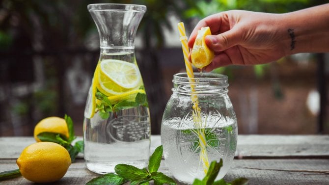 Ruka mačkající citron do vody