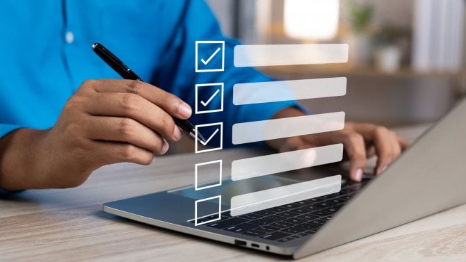 Muž v kanceláři na počítači odklikává úkoly