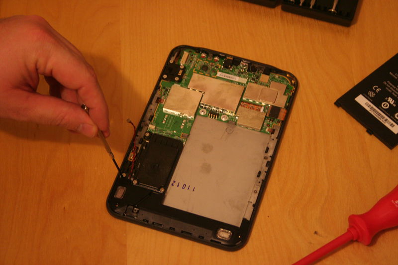 Povolte dva šroubky držící panel reproduktorů.