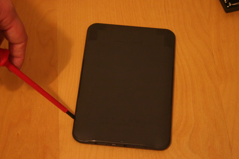 Vsuňte šroubovák na delší hraně těsně nad reproduktory. Poté jeďte po okraji a odcvakávejte plastové zámečky.