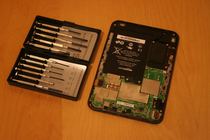 Budeme potřebovat malé šroubováky. Odšroubujte dva šrouby držící baterii.