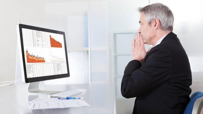 Portrét zmateného obchodníka s počítačem v kanceláři