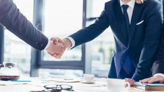 Dva lidé si podávají rukou na znamení uzavření obchodu