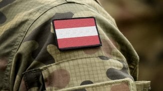 Rameno rakouského vojáka v maskáčích s vlajkou