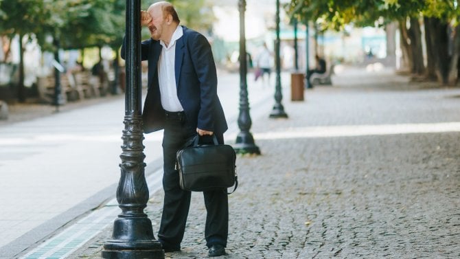 Starší nuž, který se naštvaně hlavou opírá o lampu.