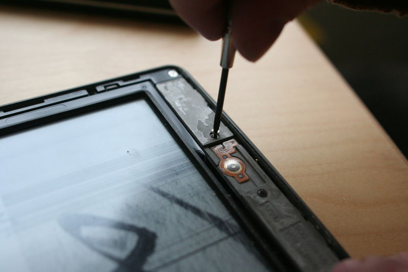 Povolíme dva šroubky okolo tlačítka home.