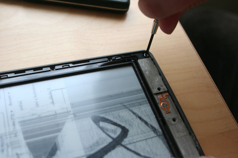 Poté odšroubujeme další čtyři šroubky v rozích rámečku.